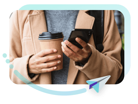 persona con móvil y café en la mano